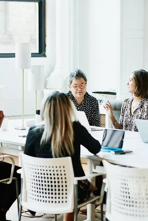 Colleagues talking at a table in a bright office