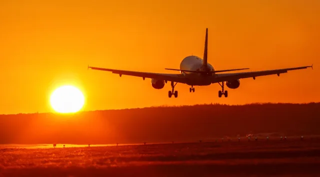An airliner landing at sunset