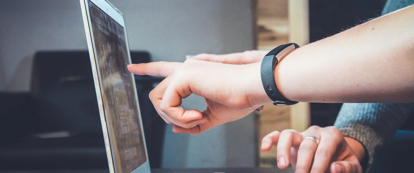 Hands pointing at a laptop screen during a review