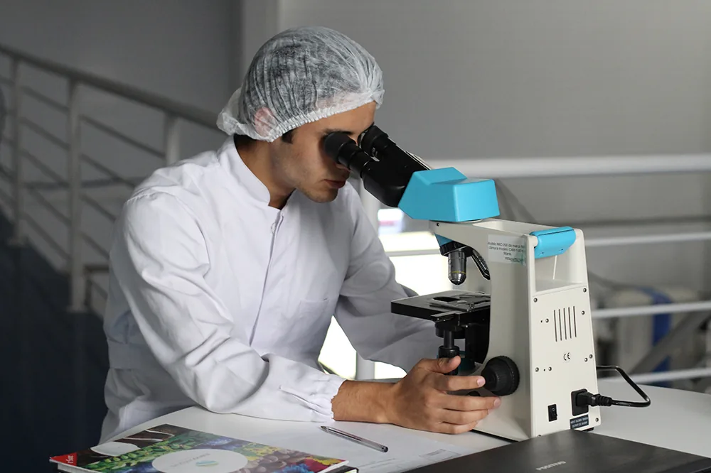 A lab technician looking into a microscope