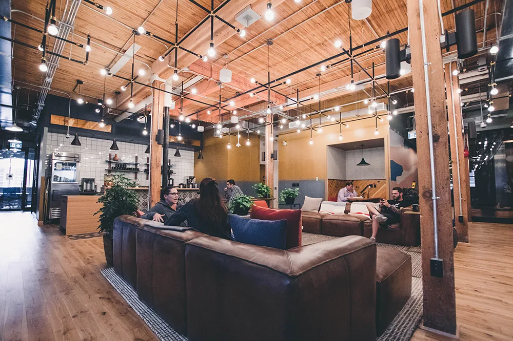 A lounge with leather sofas under string lights