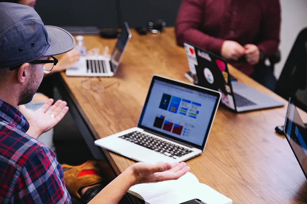 Colleagues around a table with laptops