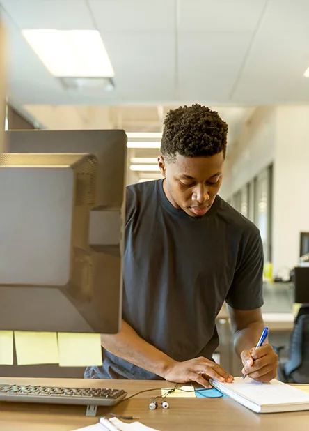 A person working at a laptop by a window
